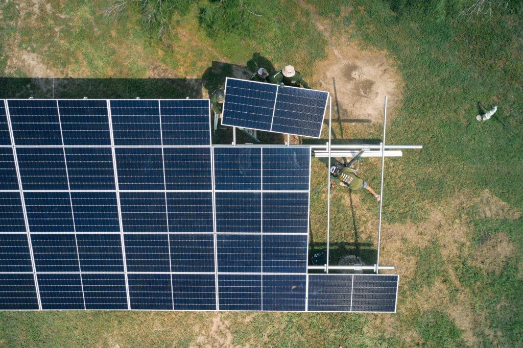 Luftaufnahme von oben nach unten, wie das Solarpanel am Bodenmontagerahmen angebracht wird