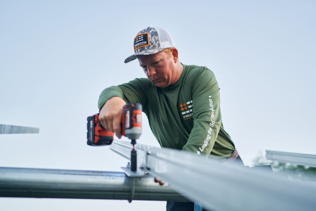 Arbeiter befestigt die Montageschienenklemmen mit einer elektrischen Bohrmaschine