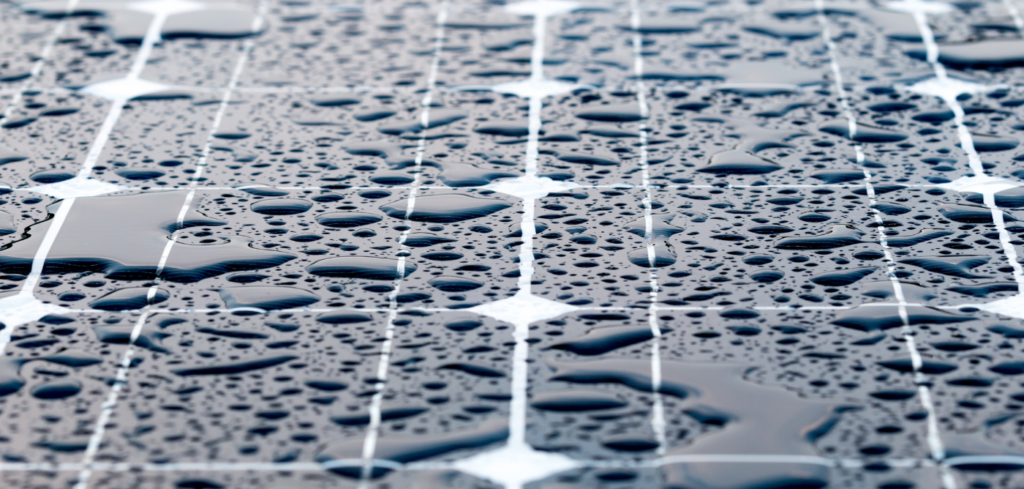 Pogled izbliza na kišu nakupljenu na površini solarne ploče.